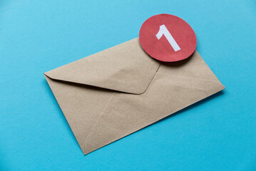 Concept of new email reminder or message alert. Brown craft envelope with a red symbol of notification on a blue background.