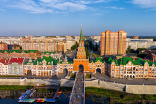 Yoshkar-Ola, Russia. Spasskaya Tower. Embankment Of Bruges. Panorama Of The City Center During Sunset. Aerial View