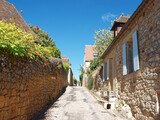 Fototapeta Uliczki - Domme majestic Bastide in Dordogne with its delightful stones perigordian houses sometimes lined with small flower gardens along quiet narrow streets 