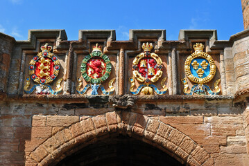 Wall Mural - Colourful Carved Heraldic Emblems over Entrance Gate to Old Scottish Castle 