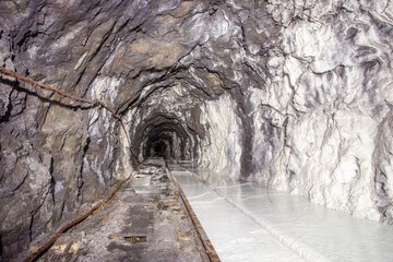 Poster - Underground abandoned white calcite marble ore mine shaft tunnel gallery passage with rails