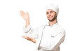 © luismolinero - Young handsome chef man over isolated background extending hands to the side for inviting to come