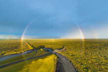 Aerial View Of Full Rainbow Over Landscape With Road And Bridge, South Iceland