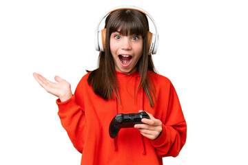 Wall Mural - Little caucasian girl playing with a video game controller over isolated background with shocked facial expression