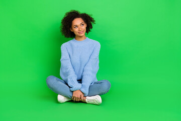 Canvas Print - Full body portrait of adorable cute person sit floor look empty space isolated on green color background