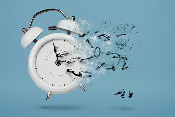 time is running out. white alarm clock with flying numbers as a symbol of lost time. the concept of 