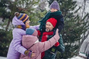 Wall Mural - Photo of cheerful positive little child wife husband dressed coats riding shoulders having fun together outdoors urban forest park