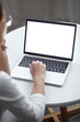 © perfectlab - Mockup white screen laptop woman using computer while sitting at table at home, back view