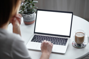 mockup white screen laptop woman using computer while sitting at table at home, back view