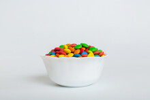 Multicolored Candies In A Bowl On A Colored Background. Birthday And Holiday Concept. Top View With Copy Space