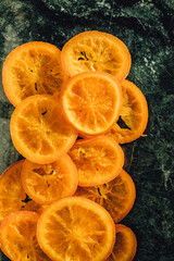 Canvas Print - Candied orange slices laid out on green marble	