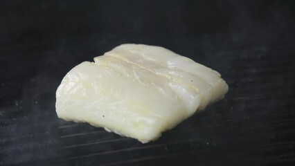 Sticker - Piece of white fish is being cocked on metal barbeque with smoke, closeup shot