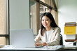 © Cavan - Young asian business woman or student working online on computer