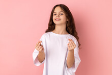 Portrait Of Proud Confident Little Girl Wearing White T-shirt Smiling And Showing Give Me Money Gesture, Asking For Payment, Allowance. Indoor Studio Shot Isolated On Pink Background.
