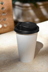 Canvas Print - Takeaway coffee cup on beige table in cafe