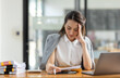 © David - Portrait of tired young business Asian woman work with documents tax laptop computer in office. Sad, unhappy, Worried, Depression, or employee life stress concept