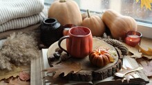 Autumn Still Life On The Windowsill, A Cup Of Tea, Candles, Pumpkins, Leaves, Thanksgiving House Interior.