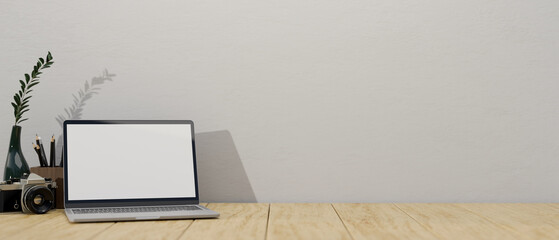 Minimal workspace with laptop mockup and copy space on wood table against the white wall.