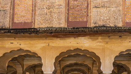 Wall Mural - A fragment of the architecture of the ancient Amber Fort. Elegant arched vaults and cracked weathered walls are visible. India. Jaipur