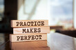 © Uuganbayar - Wooden blocks with words 'Practice Makes Perfect'.
