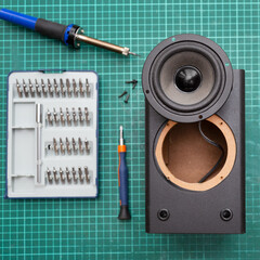 Wall Mural - Audio speaker repair concept. Square photo. Broken audio speaker and repair tools in workshop. Flat lay.