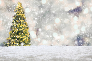 Empty white snow with blur Christmas tree with bokeh light background