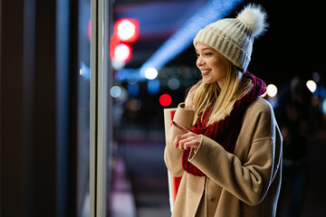 Wall Mural - Portrait of happy woman spending time with christmas shopping outdoors in city.