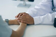 © SOMKID - female doctor hands hold female doctor hands hold  palms of patient, The doctor is consoling the patient, Doctors give hope to support health care concept.