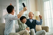 © imtmphoto - asian son father grandfather watching soccer game on TV together at home
