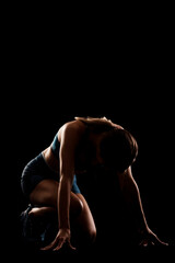 Wall Mural - Female runner in low race start position. Girl in sportswear against dark background..