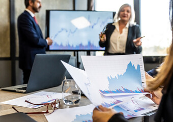 Business woman looking at a series of data and analyzes during a business meeting, unrecognizable worker studying trading investment trends