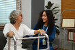 Positive female caregiver teaching senior woman to walk with walker. Assistance, rehabilitation and health