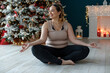 A beautiful fat woman in a sports uniform is exercising in the body to burn fat. Fitness and yoga. Sports at Christmas. High quality photo