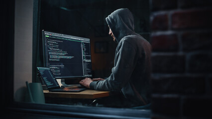 Aufkleber - Night Apartment: Evil Greedy Hacker Wearing Hoodie, Breaks into Data Servers, Does DDOS Attack, Phishing Scheme, Malware, Sends Virus. Cyber Security and Crime Concept. View From Outdoors into Window.