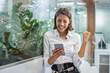 © Bojan - Excited cheerful young business woman with fist up receiving good news on smart phone and screaming in office.