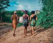 Portrait of bare-footed African women in colorful clothes walking on a field