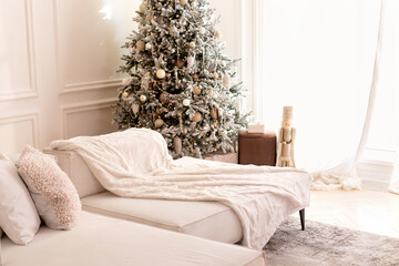 Wall Mural - Comfortable couch with three cushions and a blanket standing in bright room interior with grey carpet in a modern interior. Modern interior living room with large light corner sofa and Xmas tree.	