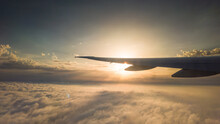 Airplane Window View To The Clouds And Sunset. Airplane Wing Above Scattered Clouds 