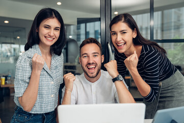 Wall Mural - Happy diverse friends watching funny video, laughing at joke, using laptop and having fun together, brainstorm together at meeting