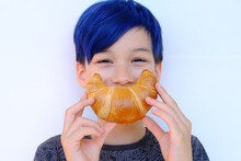 Close-up Of Child's Face, Boy Of 10 Years Old Holds Rosy Baked Croissant With Hands Near Mouth, Depicts Cheerful Smile, Concept Delicious Breakfast, Happy Childhood, Emotional Development Children
