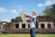 © Verin - senior man with grey hair,carry backpack and having camera see a map of the ancient site while visit Phimai Historical Park,Thailand, concept eco-tourism, archaeological site, archeology,research