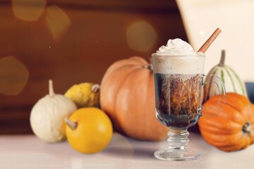 Wall Mural - Tasty sweet iced latte with cream in glass with pumpkin.