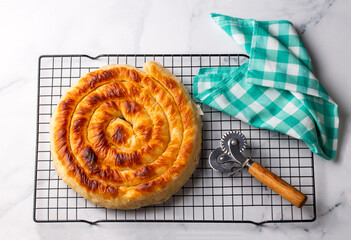 Wall Mural - Traditional Turkish pastry with spinach. (Turkish Name: Ispanakli Kol Boregi, Bosnak boregi). Handmade pastry with spinach filling.