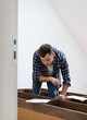 © Barillo_Images - Man assembling new wardrobe at home looking at instruction manual.