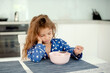 girl doesn't want to eat porridge. The child is capricious and refuses to eat. Poor appetite in a child. morning concept