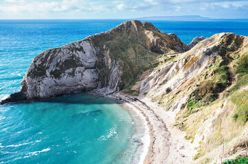 Wall Mural - Beautiful views of nature on way to Durdle door in Lulworth, Dorset, United Kingdom. Part of Jurassic Coast World Heritage Site, view of stone rock formations and blue turquoise sea, selective focus