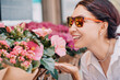 © EdNurg - A girl buyer and a client choose bouquets and flowers in pots at market and florist shop on a city street