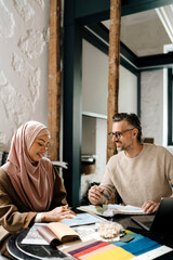 Wall Mural - Multiracial woman and man working together in workshop