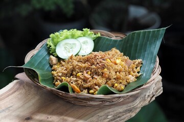 Closeup of Indonesian delicious fried rice served on a green leaf in a straw basket