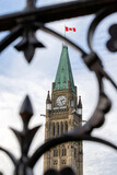 Canadian Parliament building with flag in Ottawa, Canada. View through fence